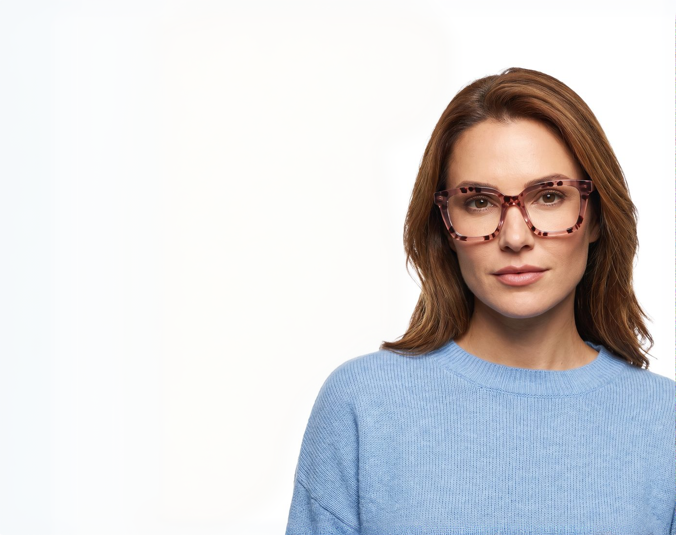 A woman wearing the pink tortoiseshell SAINT readers